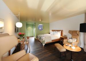 韦斯巴德霍夫魏斯巴特酒店的酒店客房带一张床、一张桌子和椅子