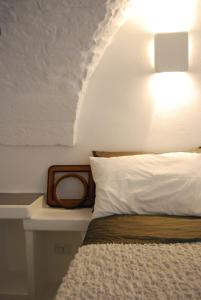 奥斯图尼7号爱亚祺宾馆的一间卧室配有一张带白色枕头和灯的床