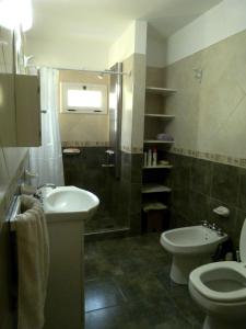 坦季El Pinar - Hospedaje Serrano的一间带水槽、卫生间和淋浴的浴室