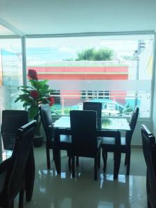 里奥阿查Karin Hotel的一间带桌椅和窗户的用餐室