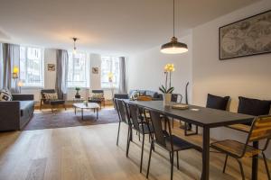 卢塞恩KoBi Apartments Hirschenplatz的用餐室以及带桌椅的起居室。