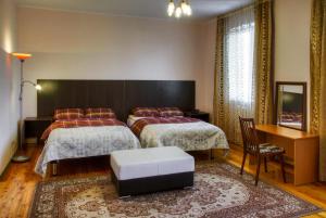 阿拉木图萨多瓦娅酒店的酒店客房设有两张床和一张桌子。