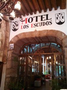 帕茨库卡罗Hotel Los Escudos的大楼前的一座酒店标志