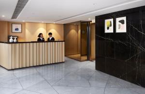 香港康境酒店的两个人站在大厅的柜台上