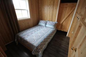 泰道沙克Tadou-Shack的一个小房间的一个床位,设有窗户