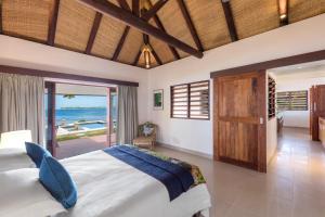 维拉港依拉塔普海滩度假酒店的一间卧室配有一张床,享有海景