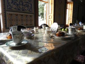 布哈拉Hotel Mosque Baland的桌子上放着杯子和盘子
