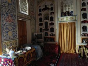 布哈拉Hotel Mosque Baland的一间房间,房间内设有桌子和窗帘