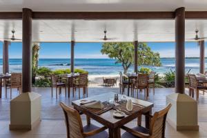 维拉港依拉塔普海滩度假酒店的海滩上的餐厅,配有桌椅
