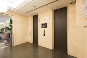 大阪Sotetsu Grand Fresa Osaka-Namba的大楼内带黑色门的走廊