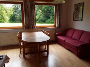 弗尔克马克特Gästehaus Kuchernig的客厅配有红色的沙发和桌子