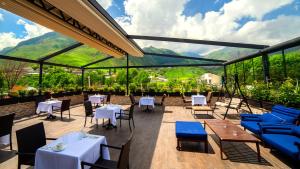 卡兹贝吉卡兹别吉波尔塔考卡斯亚酒店的餐厅配有桌椅,位于山脉的背景中。