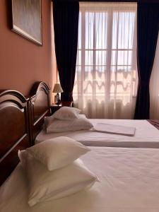 曼加利亚Hotel Rion的卧室设有两张床,带窗户