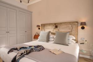 罗马Borgo Pio Charme的一间卧室配有一张白色大床,上面有书