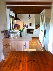 布迪皮拉格斯Casa Boo de Piélagos - Playa de Liencres的一间大厨房,在房间内配有木桌