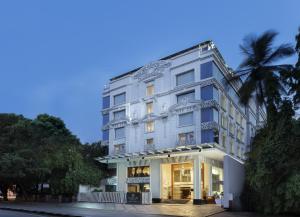 班加罗尔La Marvella, Bengaluru的一座白色的建筑,前面有棕榈树