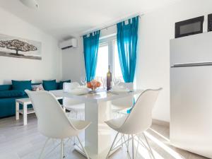 奥米沙利Lavish Apartment in Omi alj with Rooftop Terrace的厨房以及带白色桌椅的用餐室。