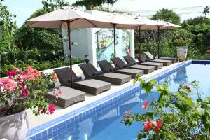 安帕瓦安帕瓦别墅 的游泳池旁的游泳池配有椅子和遮阳伞