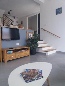 希贝尼克Villa Belitzein with swimming pool的一间带电视、桌子和楼梯的客厅
