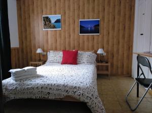 波尔特沃尤文图斯旅馆的卧室配有白色的床和红色枕头