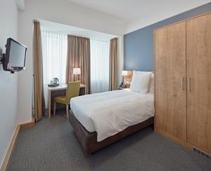 卢森堡城市酒店的酒店客房设有一张大床和一张书桌。