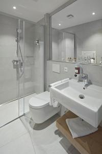 卢森堡城市酒店的一间带水槽、卫生间和淋浴的浴室