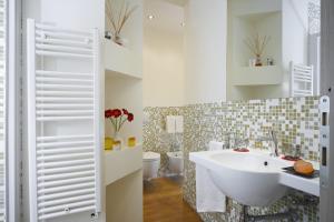 佛罗伦萨瑞雷斯广场酒店的一间带白色水槽和2个卫生间的浴室