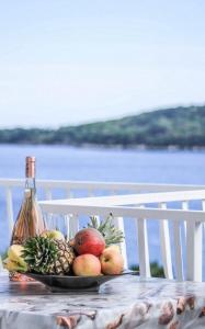 莫鲁纳特Villa Marija - Sea View Rooms的桌上的水果盘和一瓶葡萄酒