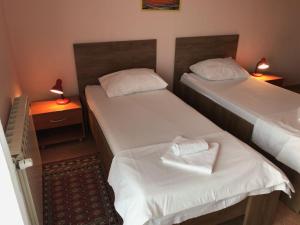斯普利特Guest House Ivo的小型客房配有两张单人床和两盏灯。