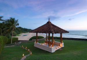 本托塔Jetwing Saman Villas的靠近大海的草地上灯火通明的凉亭