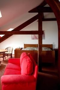 圣费利切德尔贝纳科Punta Del Corno Agriturismo的客厅配有红色的沙发和床。