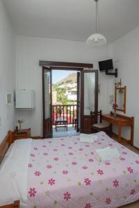 斯科拉Villa Zacharo的一间卧室配有一张带粉红色鲜花的大床