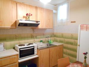 金尼昂Agnes Rooms的厨房配有木制橱柜、水槽和微波炉