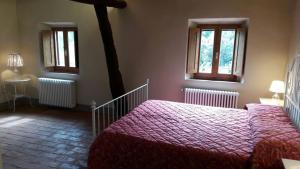 圣吉米纳诺La Tenuta di Castelvecchio的一间卧室设有两张床和两个窗户。