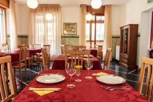 Martina OlbaAlbergo Minetto的用餐室配有带盘子和玻璃杯的桌子