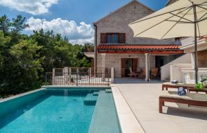 苏曼婷Villa Nova Brac的一个带遮阳伞和房子的游泳池