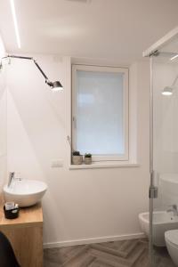 加尔达湖滨玛丽亚别墅酒店的白色的浴室设有水槽和窗户。