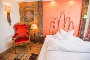 奥格斯堡Ringhotel Alpenhof - Patchworkhotel的一间卧室配有一张床和一张红色椅子