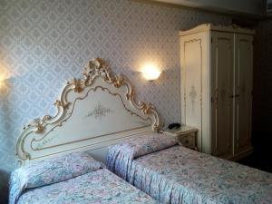 威尼斯戴安娜酒店的一间带两张床和大床头的卧室