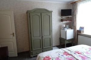 东卡佩勒Wondergem的一间卧室配有绿色橱柜和冰箱