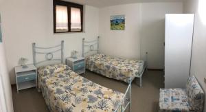 皮诺港MARIA'S HOUSE的一间设有两张床、两张桌子和镜子的房间