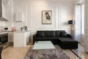 瓦伦西亚Baron Suites Reina的客厅配有黑色沙发和桌子