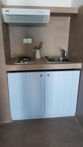 KástronAegean Eye Apartments的厨房配有白色橱柜和水槽