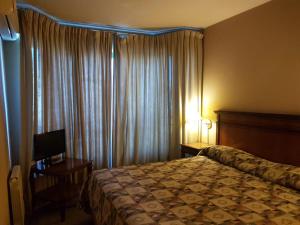 门多萨Millenium Mendoza Apartments的酒店客房,配有床和电视