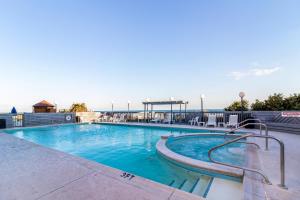 派恩诺尔肖尔斯Crystal Coast Oceanfront Hotel的一座带椅子的大型游泳池,其背景是大海