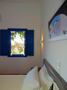 乔拉弗雷恩多斯Aegeo Hotel的一间卧室设有一张床和一个窗口