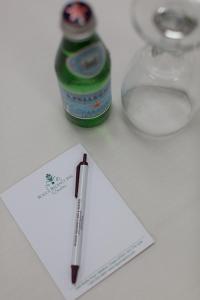 梅德福丽晶套房酒店 的纸上的笔,旁边是一瓶苏打水