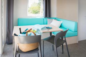 卡斯特拉讷圣母露营酒店的一间带桌子和蓝色沙发的用餐室