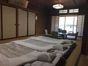 山之内町大丸屋日式旅馆的一张桌子的房间里设有两张大床
