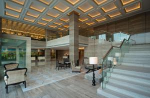 卢迪亚纳凯悦卢迪亚纳酒店的大堂设有楼梯、桌椅